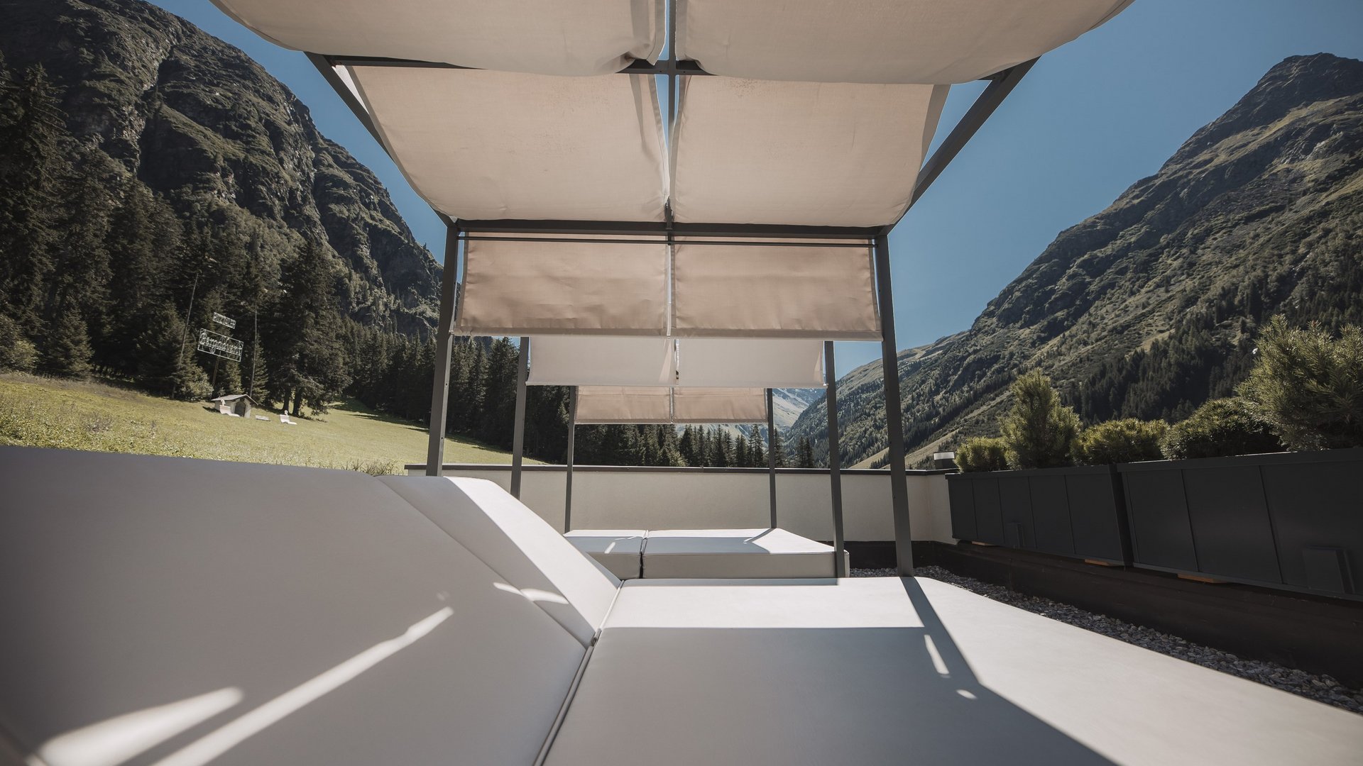 Live from St. Leonhard im Pitztal Sun loungers with canopy on terrace overlooking mountainous landscape under clear sky