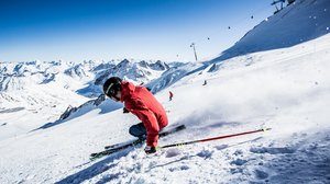 Nicht irgendein Pitztal-Resort: Alpine Resort Sportalm! Skifahrer in roter Jacke fährt im Schnee auf sonniger Bergpiste
